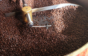 Swirling coffee beans roasting in a pan.